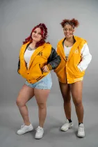 Classic Varsity Jacket 50 Two models wearing Reign Gear women's yellow and black water-repellent hooded varsity jackets