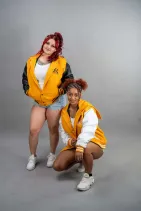 Classic Varsity Jacket 45 Two models wearing Reign Gear women's classic varsity jackets in yellow and black and yellow and white colorways
